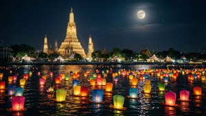 滿月下充滿漂浮燈籠的河流，背景是 Wat Arun 寺廟。