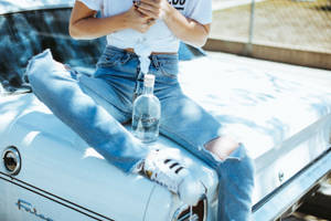 人坐在復古汽車引擎蓋上，手持伏特加瓶 — 復古gif 壁紙