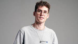 戴眼鏡穿灰色運動衫的年輕男子工作室肖像
