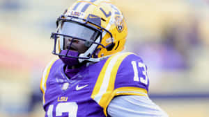LSU 足球員身穿紫色同金色球衣，號碼13。