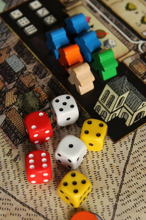 色彩繽紛的骰子和木製遊戲棋子位於細節豐富的棋盤遊戲地圖上。