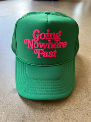 綠色卡車司機帽，粉紅色「Going Nowhere Fast」文字，櫃檯上 — Kindle 壁紙