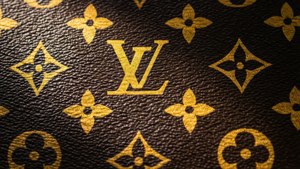 棕色皮革帶有金色 Louis Vuitton 字母組合圖案和紋理縫線。