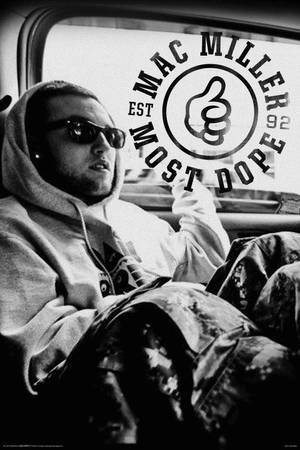 Mac Miller 穿著連帽衫和太陽眼鏡坐在車裡，車窗上有「Most Dope」標誌。