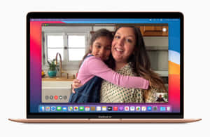 在玫瑰金色 MacBook Air 上進行視像通話時擁抱的女士和孩子。