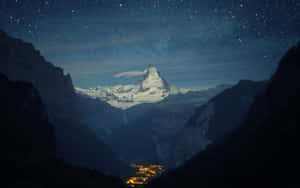 星空下積雪的山頂與山谷中發光的村莊