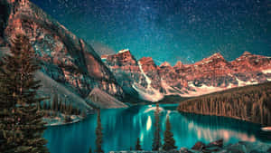被白雪覆蓋的山脈和松樹環繞的綠松石湖上空的星空。