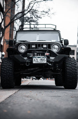 帶有科羅拉多車牌的黑色Jeep Wrangler停泊在城市街道上。