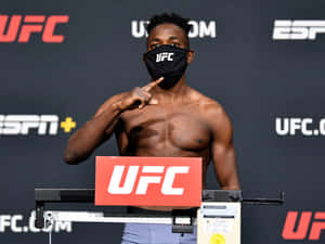 UFC拳手在稱重時戴着口罩指着胸口。