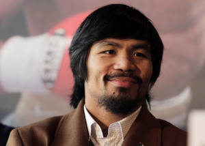 Manny Pacquiao 喺記者會上著住棕色外套微笑。