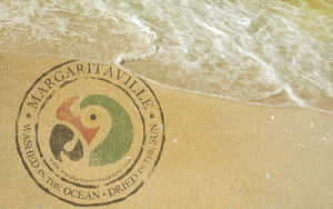 沙灘上繪製的Margaritaville標誌，海浪沖刷其上。