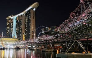 濱海灣金沙和螺旋橋在夜間亮起，水面倒影。