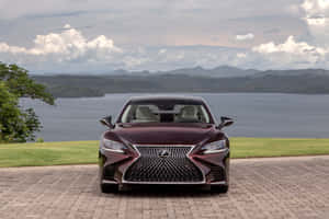 栗色Lexus房車停在磚砌車道上，俯瞰湖泊和山脈。 — Surface Pro 壁紙