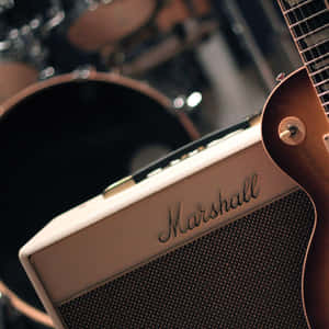 奶油色 Marshall 擴音器同 sunburst 結他，背景有鼓。