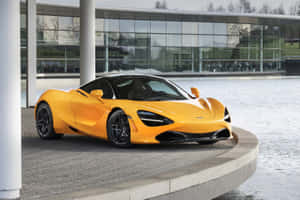 橙色McLaren 720S跑車停泊在玻璃建築旁的水邊。