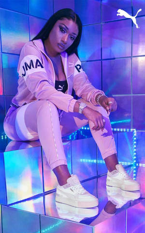 身穿粉紅色 Puma 服裝的女性在發光平台上擺姿勢。