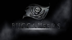 黑暗煙霧中，海盜旗上有骷髏頭和劍，位於Buccaneers字樣上方。