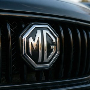 黑色垂直條紋汽車格柵上的鍍鉻MG標誌。