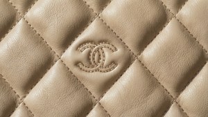米色絎縫皮革，帶有縫製的 Chanel 標誌。