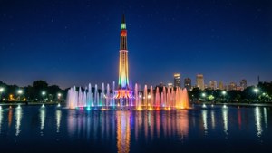 星空下，彩色噴泉燈光映照在水面，照明塔和城市建築