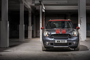 銀色MINI Countryman，紅色車頂，停在廢棄倉庫中。