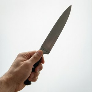 手握黑色手柄、不銹鋼刀片的廚師刀