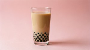 一杯珍珠奶茶，黑色珍珠喺粉紅色表面上