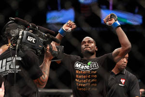 UFC拳手在八角籠內高舉拳頭慶祝勝利。