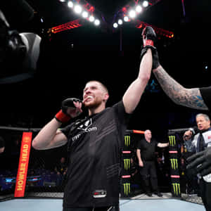 MMA拳手在八角籠內舉起手臂慶祝勝利。