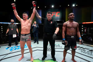 UFC 拳手在八角籠中獲勝，裁判舉起他的手。 — 運動 壁紙
