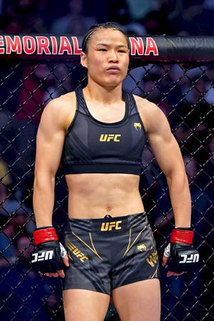 穿著UFC裝備的女性MMA拳手站在八角籠內。