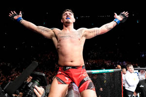 MMA選手在八角籠中高舉雙臂慶祝勝利。