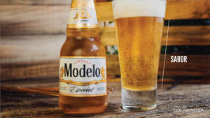 冰凍的Modelo Especial啤酒瓶和玻璃杯在木桌上。