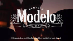 Modelo啤酒標誌，帶有獅子和1925年橫幅，背景為黑暗的日落。