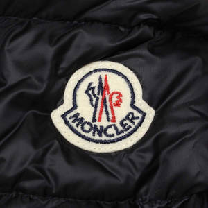 黑色絎縫外套上 Moncler 標誌布章的近距離特寫。