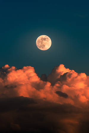 藍色午夜天空中的月亮與橙色雲朵。從上方俯瞰的美麗傍晚風景。