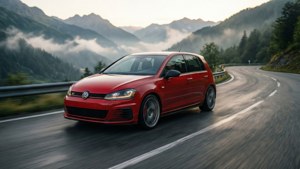 紅色福士 Golf R 在蜿蜒的山路上行駛，背景是霧氣瀰漫的森林山丘。