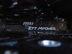 黑色 MSI Z77 MPower 主機板特寫，帶有藍色電容和白色文字。 — 1080x2400 壁紙