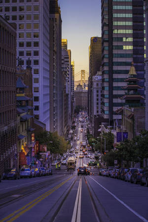 暮色中的市中心街道，有纜車和高聳的建築物