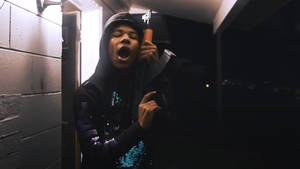 穿連帽衫的人夜晚在黑暗小巷中拿著棒球棍尖叫。