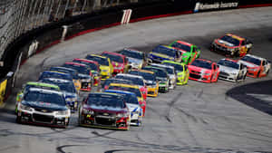 日落時分，NASCAR賽車在高速過彎時緊密擠在一起。