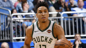 身穿Bucks球衣的籃球運動員在比賽中運球。