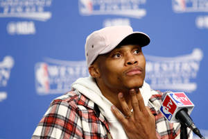 NBA記者會上，籃球運動員手托下巴。