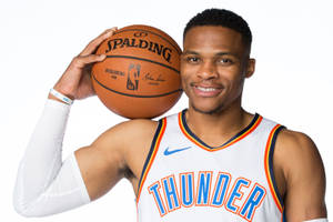 身穿雷霆隊球衣的職業籃球運動員手持 Spalding 籃球。