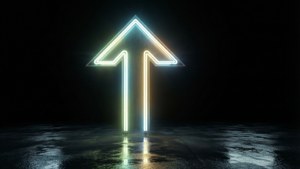 夜間潮濕路面上指向上的發光霓虹箭頭