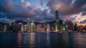 日落時分的香港天際線，霓虹燈光在海港水面閃耀生輝。