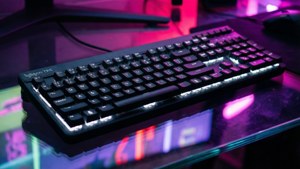 黑色Logitech鍵盤 白色背光 玻璃桌 粉紅紫色霓虹燈
