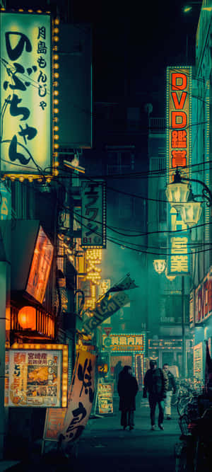 霓虹燈照亮了夜晚東京狹窄的街道，人們在其下行走。 — Pixel 9a 壁紙