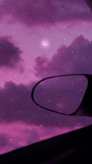 汽車側鏡反射出帶有新月的紫色星空夜空。