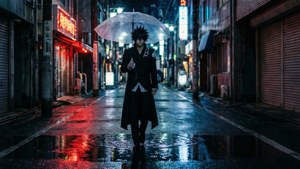 動漫角色在夜晚霓虹燈照亮的街道上撐傘雨中行走。
